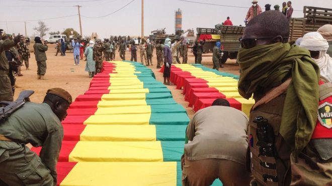 Солдаты стоят возле гробов на церемонии похорон жертв теракта-самоубийства 18 января, разорвавшегося в лагере, объединяющем бывших повстанцев и проправительственную милицию в Гао, в неспокойном северном Мали, 20 января 2017 года в Гао
