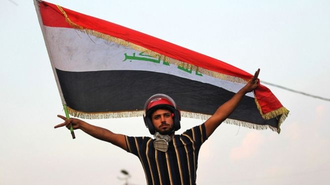 An Iraqi protester poses with a national flag during a demonstration in Baghdad on 29 October 2019