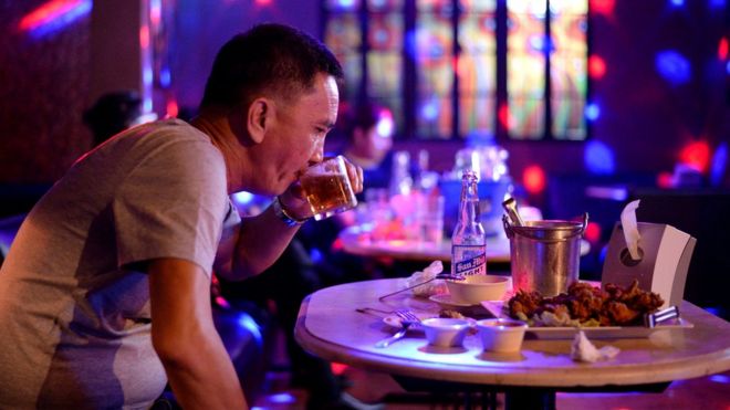 Клиент пьет пиво в ночном клубе в Давао Сити