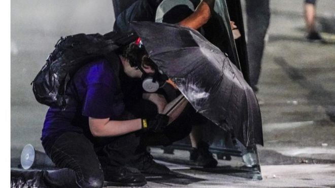 Manifestantes tentam se proteger de balas de borracha e gás lacrimogênio em Kenosha, Washington