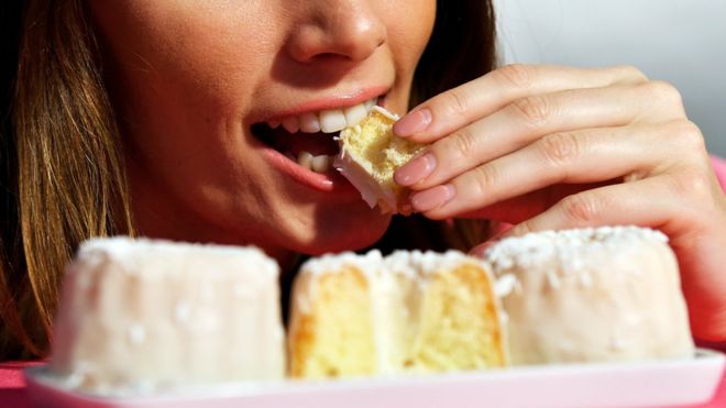 Mujer comiendo pasteles.