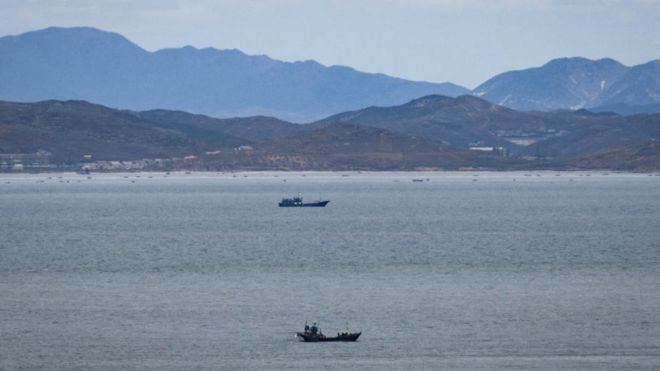 Неопознанные рыбацкие лодки у побережья Северной Кореи с точки зрения контролируемого Южной Кореей острова Ёнпхён возле спорных вод Желтого моря на рассвете.