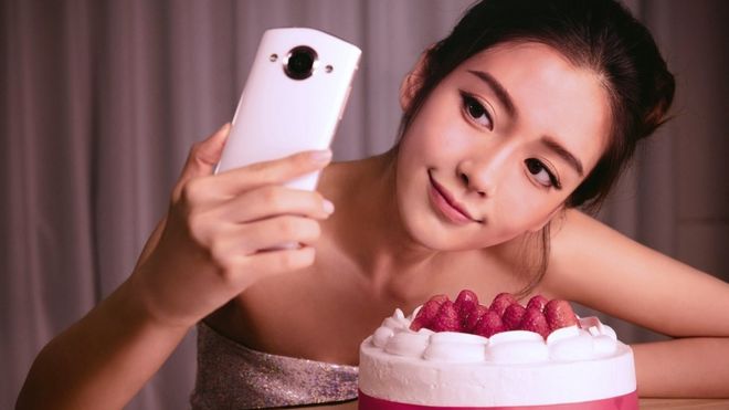 Mujer china tomando un selfie para una promoción de Meitu
