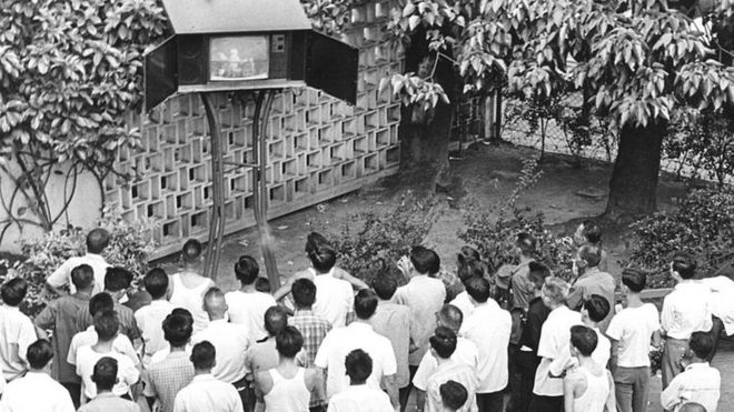 In a park, viewers gather around to watch the television broadcast of the Apollo 11 moon landing, Hong Kong, July 1969