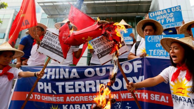Протестующие сжигают поддельную ракету во время митинга возле китайского консульства в финансовом районе города Макати, Филиппины, чтобы осудить предполагаемое размещение Китаем ракет "земля-воздух" на спорных островах у Южно-Китайского моря, в пятницу, февраль. 19, 2016
