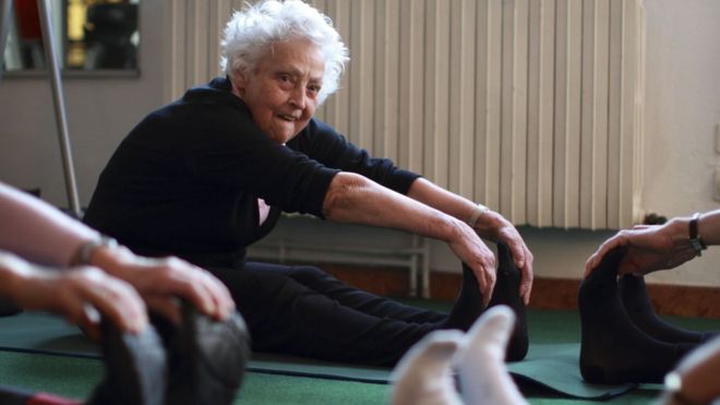 Пожилая женщина тренируется с другими