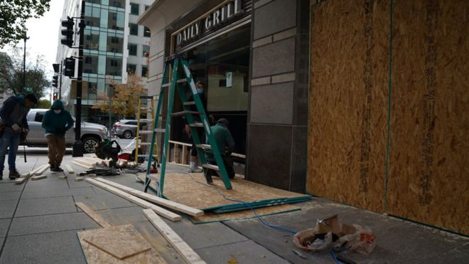 рабочие заколачивают витрины