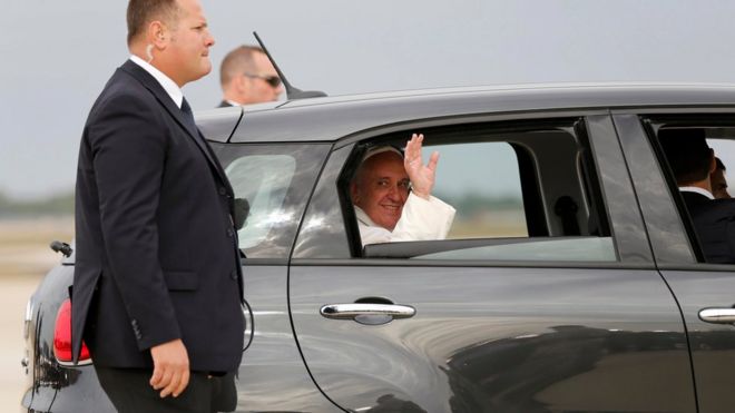 Папа Фрэнсис машет рукой, когда его уезжают на модели Fiat 500 после прибытия в Соединенные Штаты на Объединенной базе Эндрюс под Вашингтоном 22 сентября 2015 года