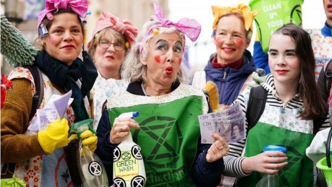 Manifestantes disfrazados denunciando el lavado verde