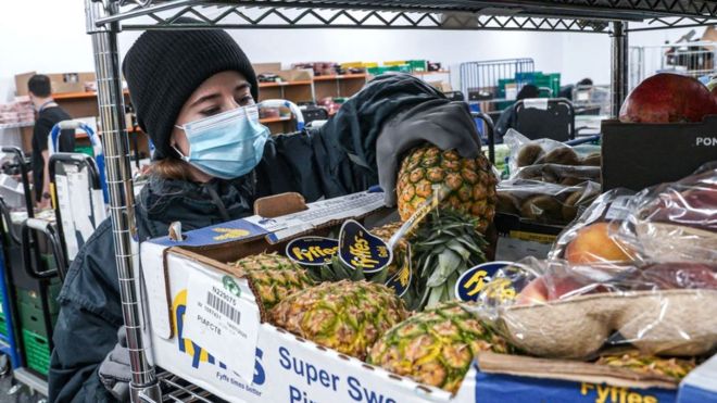 Работник распределительного центра Amazon собирает еду