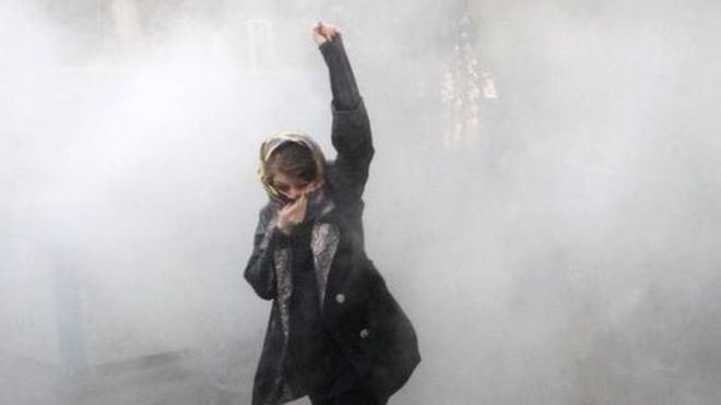 Una joven en medio del gas lacrimógeno
