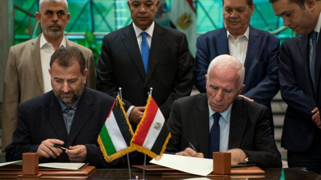 Палестинский член ЦК ФАТХ Азам аль-Ахмед (справа) и заместитель главы политбюро ХАМАСа Салех аль-Арури подписывают соглашение между двумя палестинскими группировками в Каире, Египет, 12 октября 2017 года