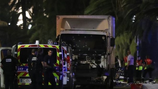 French police stand near the van that ploughed into crowds in Nice