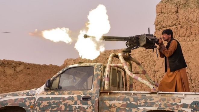 Боец антиталибского ополчения стреляет из пулемета в окрестностях Лашкаргаха