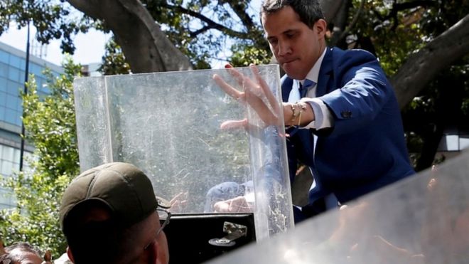 Juan Guaidó, trepado a una reja frente a la Asamblea Nacional.
