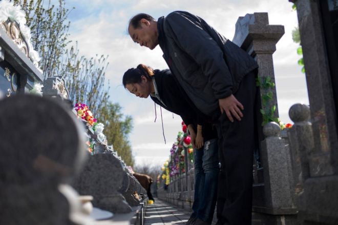 Члены семьи кланяются на могиле 1 апреля 2017 года в преддверии ежегодного фестиваля Цинмин, или Дня Гробниц, на кладбище в Дагантангкуне, в 30 км к востоку от Пекина