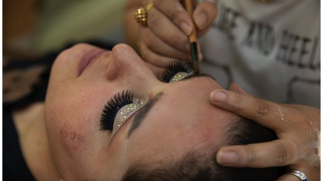 Una mujer recibiendo maquillaje en un salón de belleza en Kabul, 8 de julio, 2023, antes del cierre de estos locales