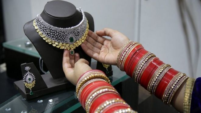Индийская женщина смотрит на золотые украшения в магазине 09 ноября 2016 года.