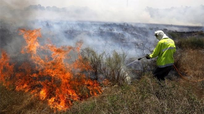 Израильский пожарный борется с пожаром, вызванным пылающим воздушным змеем из Газы (05/06/18)