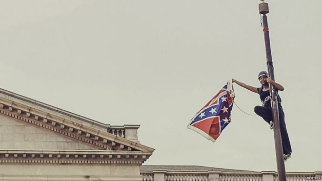 Бри Ньюсом снимает флаг Конфедерации с шеста в здании Государственного дома в Колумбии, штат Южная Каролина, 27 июня 2015 года.