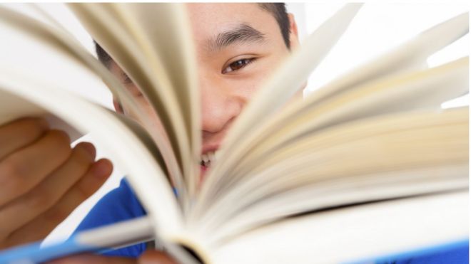 Chinese kid flipping the pages of a book