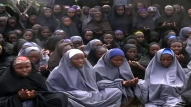На этой фотографии, сделанной 12 мая 2014 года, изображен снимок экрана, снятый с видео нигерийской исламистской экстремистской группы «Боко харам», полученного AFP, на котором изображены девочки, одетые в хиджаб во всю длину и молящиеся в неизвестном сельском месте.