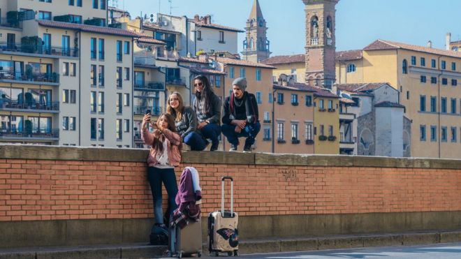 Группа молодых людей фотографирует себя во Флоренции