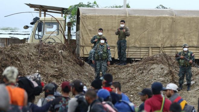 Militares peruanos y migrantes a ambos lados de la frontera.