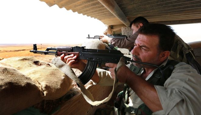 Иракские курдские бойцы пешмерга нацеливают свое оружие на город Башека, на передовой борьбы между курдскими войсками и боевиками из так называемого Исламского государства
