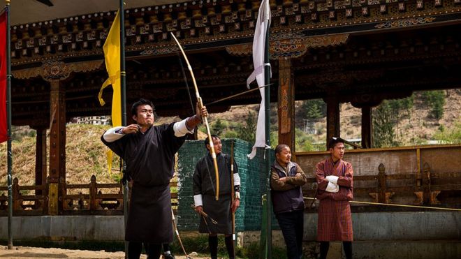 Местные мужчины практикуют свои навыки стрельбы из лука, взятые в Бутане, апрель 2016 года