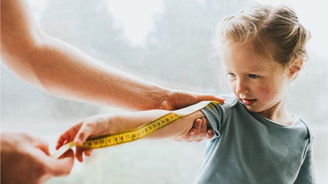 Una niña con una cinta métrica