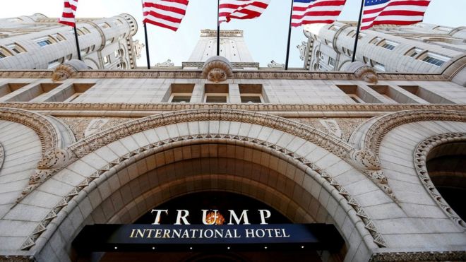 Flags fly above the entrance to the new Trump International Hotel on its opening day in Washington, DC