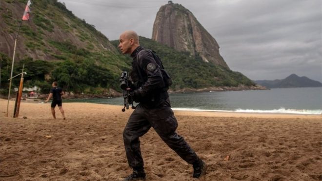 Сотрудник военной полиции патрулирует во время полицейской операции на пляже Вермелья в районе Урка, Рио-де-Жанейро, Бразилия, 8 июня 2018 года