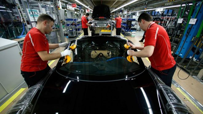 Trabajadores en una fábrica de autos.