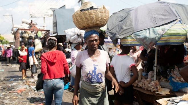 Una mujer lleva una canasta en la cabeza en el mercado "Kokoye" en Petion-Ville, Puerto Príncipe, luego de que un grupo misionero fueran secuestrados en Haití el sábado, en Puerto Príncipe, Haití. 17 de octubre de 2021