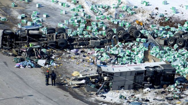 Аэрофотоснимок обломков показывает разбросанный по снегу груз грузовика, сильно поврежденный автобус и перевернутый прицеп