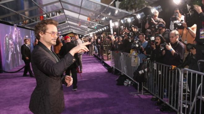 Роберт Дауни-младший стоит перед фотографами на красной дорожке премьеры фильма «Мстители: бесконечность» в Лос-Анджелесе