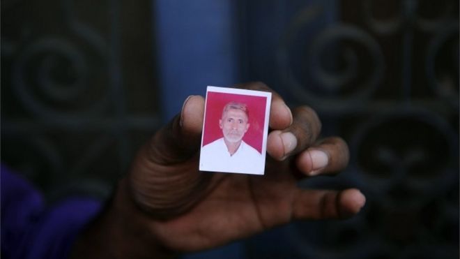 Родственник держит фотографию убитого индийского жителя деревни Мохаммада Ахлака в своем доме в деревне Бисада,