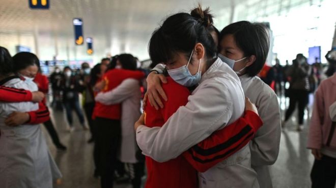 Медицинский персонал из провинции Цзилинь (в красном) обнимает медсестер из Ухани после снятия изоляции от Covid-19, 8 апреля 2020 г.