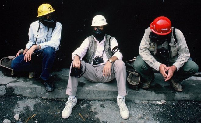 Чарли Коул сидит с двумя другими мужчинами в противогазах и шлемах