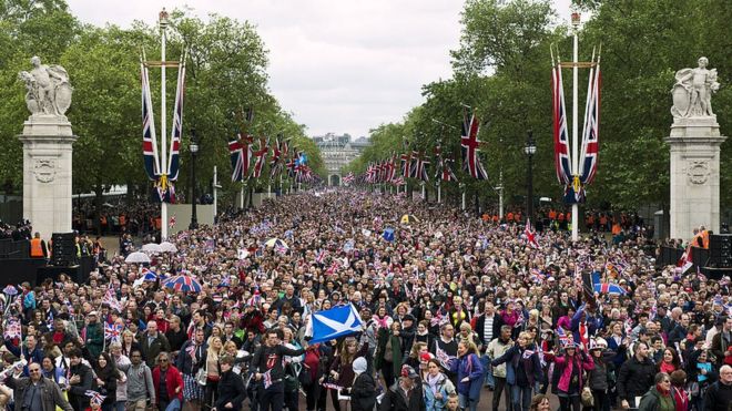 Huge crowds cheering with Britain's Union flags march down the Mall towards Buckingham Palace to celebrate the Queen's Diamond Jubilee