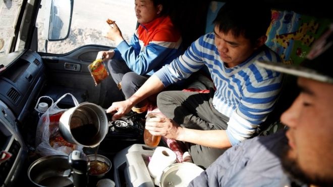 Camioneros de Mongolia cocinan y comen arriba del camión.
