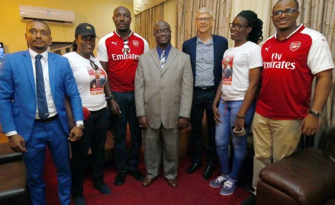 Бывший футбольный тренер Арсен Венгер (3-R) позирует для фотографии с местными фанатами «Арсенала» по прибытии в международный аэропорт Робертс в Харбеле, Либерия, 22 августа 2018 года.