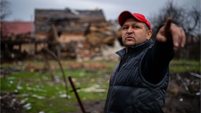 Un civil en el norte de Kyiv señala el lugar donde las fuerzas rusas destruyeron su casa