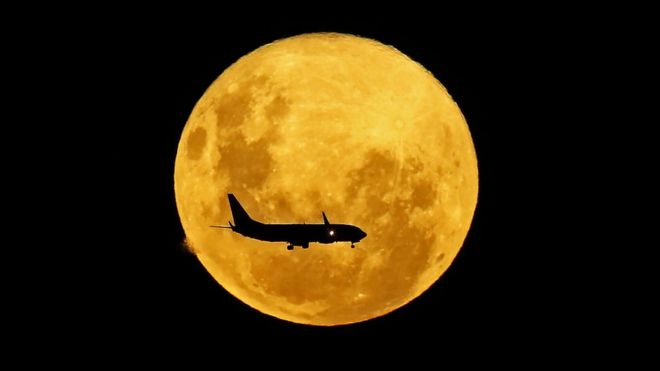 Un avión pasa por delante de la Luna, desde Curitiba, Brasil, el 9 de marzo de 2020.