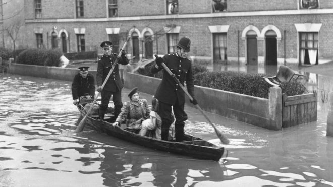 Полицейские гребут по улице во время наводнения в Лондоне в 1947 году