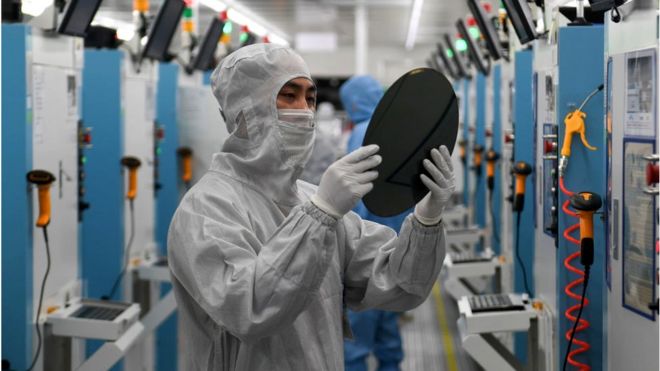 Employees work on the production line of silicon wafer at a factory of GalaxyCore Inc. on May 25, 2021 in Jiashan County, Jiaxing City, Zhejiang Province of China
