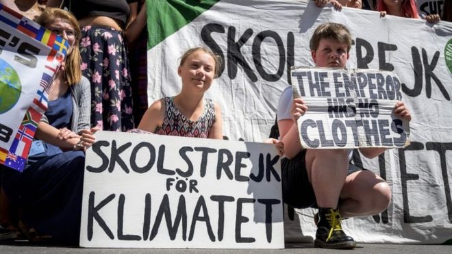 Грета Тунберг позирует с другими молодыми активистами по борьбе с изменением климата на митинге