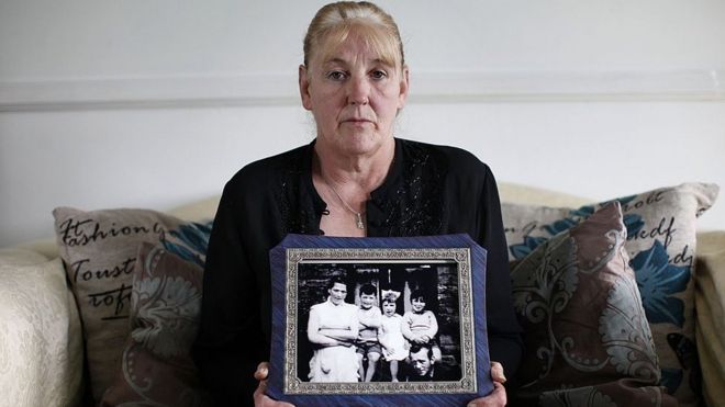 La hija mayor de Jean McConville, Helen, con una foto de su madre en la también aparece ella y algunos de sus hermanos.