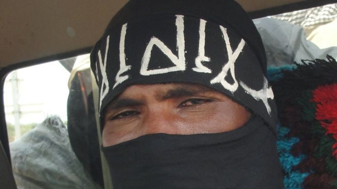 A close-up shot of an Islamist militant wearing a black veil which only shows his eyes